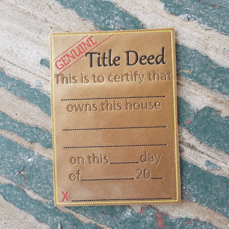 May include: A gold-colored card with the text "GENUINE Title Deed" and "This is to certify that ____ owns this house on this ____ day of ____ 20____" with an "X" at the bottom.