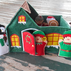 May include: A felt Christmas house playset with a red door and yellow windows. The house is surrounded by felt finger puppets of a snowman, penguin, elf, gingerbread person, and a polar bear.