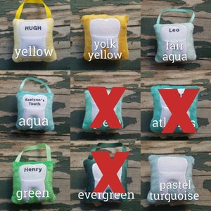 May include: Nine tooth-shaped plush pillows in various colours, including yellow, aqua, green, and turquoise. Each pillow has a different name embroidered on it, such as "Hugh", "Leo", "Raelynn's Tooth", and "Henry".