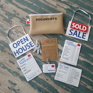 May include: A set of play pretend real estate signs for kids. The signs include "Open House", "Sold", "For Sale", "Home Inspection", "Loan Application", "Title Deed", and "Realtor".