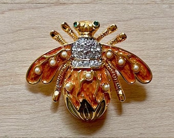 Broche vintage de abeja con esmalte verde y naranja de lirio de los valles en tono dorado de Joan Rivers. Joyas de Joan Rivers. Ideas de regalos vintage. Abeja de Joan Rivers.