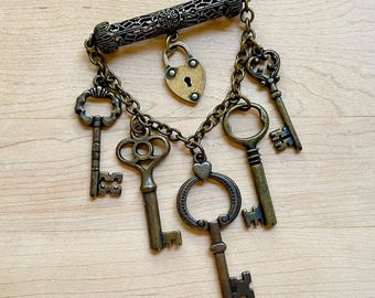 Broche vintage de Joan Rivers con candado y llave en tono latón antiguo. Joyas de Joan Rivers. Ideas de regalos vintage. Broche "La llave de mi corazón". Pin de regalo para San Valentín.