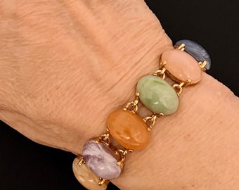 May include: A gold chain bracelet with oval-shaped gemstones in shades of pink, green, orange, and purple.