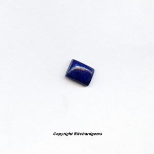 May include: A rectangular, dark blue lapis lazuli gemstone with gold flecks.