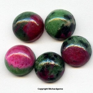 May include: Five round, green and pink gemstones. The gemstones are smooth and have a polished finish.