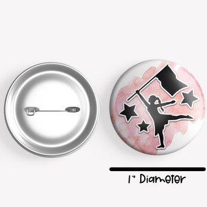 May include: A 1-inch diameter button featuring a silhouette of a color guard performer holding a flag, with pink watercolor splatters and stars in the background.