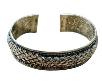 Pulsera tipo brazalete tejida de plata de ley FAS 925 con diseño artesanal llamativo.