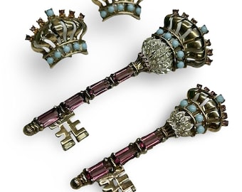 Conjunto de broche y pendientes de clip de plata esterlina con forma de corona y llave, circa 1947, de Jewels by Josanna.