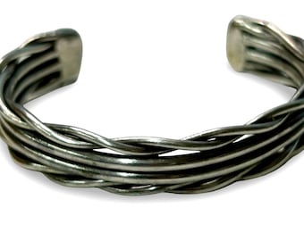 Pulsera tipo brazalete de plata de ley con alambre retorcido y diseño artesanal llamativo.