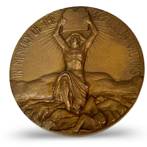 May include: Bronze commemorative medal with a central figure holding tablets, surrounded by rays of light. The inscription reads "IN MEMORY OF THE 6 MILLION VICTIMS". The medal features a relief of figures and landscape elements.