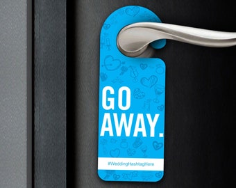 May include: A blue door hanger with the words "GO AWAY" in white block letters. The hanger has a pattern of small white doodles and is hanging on a silver door handle.
