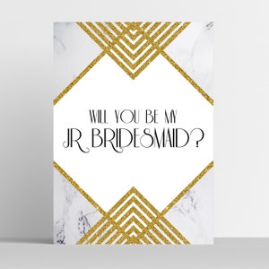 May include: A white card with gold glitter geometric designs and marble-like background. The text "WILL YOU BE MY JR BRIDESMAID?" is displayed in black, elegant font. Perfect for asking a junior bridesmaid.