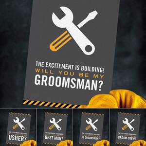 Può includere: Biglietto d'invito grigio scuro con una chiave inglese e un cacciavite bianchi, e il testo "THE EXCITEMENT IS BUILDING! WILL YOU BE MY GROOMSMAN?" Ulteriori biglietti chiedono "USHER?", "BEST MAN?", "JR GROOMSMAN?" e "GROOM CREW?"