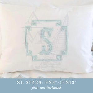 Pode incluir: Uma almofada retangular branca com uma letra S bordada em azul claro dentro de uma moldura geométrica. A almofada tem bordas recortadas com acabamento em azul claro. O texto diz: XL SIZES: 8X8"-13X13" font not included.