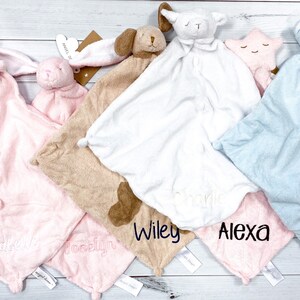 May include: Five personalized baby blankets with different animal characters. The blankets are in pink, brown, white, blue, and pink. The names "Madison", "Brooklyn", "Wiley", "Alexa", and "Davis" are embroidered on the blankets.