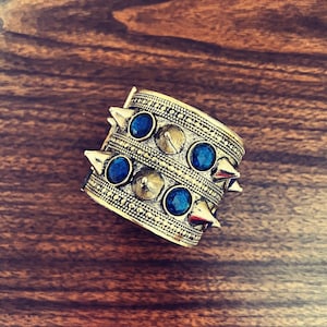 Hinged Kuchi cuff with bright blue “stones”.