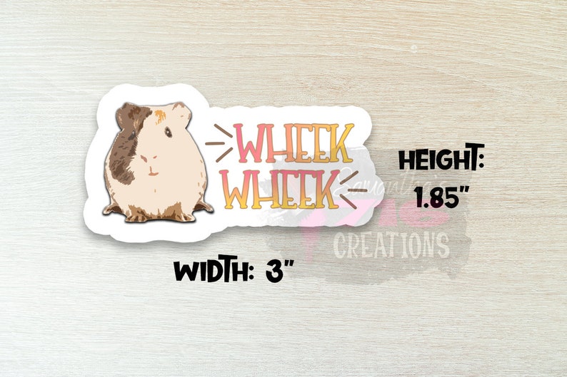 Op de afbeelding: Een witte sticker met een cartoon cavia en de tekst "Wheek Wheek" in roze en geel. De sticker is 3 inch breed en 1,85 inch hoog.