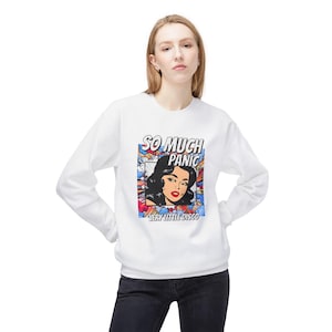 May include: White sweatshirt featuring a pop art graphic with a woman's face, the words "SO MUCH PANIC" and "VERY LITTLE DISCO". The graphic has a colorful, comic book style. The sweatshirt has long sleeves.