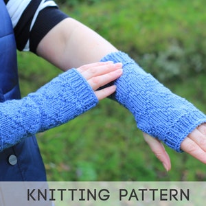 May include: A pair of blue knitted wrist warmers with a textured pattern.  KNITTING PATTERN.