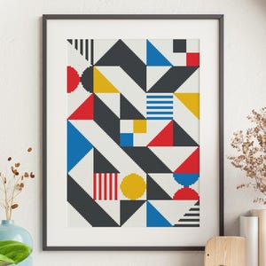 May include: A framed print of a geometric abstract design with black, white, red, yellow, and blue shapes.