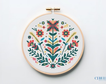 May include: A colorful floral embroidery pattern in a round wooden embroidery hoop. The design features a central flower with four petals, surrounded by smaller flowers and leaves in shades of red, yellow, green, and blue.