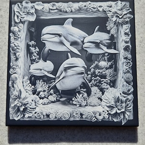 May include: A square, monochrome tile depicting a detailed relief of four dolphins in an underwater environment. The dolphins are surrounded by coral and framed by a decorative border of flowers and marine life.