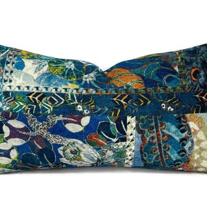 May include: A blue and white patterned throw pillow with a geometric design. The pillow is made of a soft, comfortable fabric and features a variety of colors, including blue, white, orange, and green.