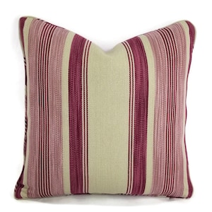 May include: A striped throw pillow with a beige and burgundy color scheme. The pillow is made of a soft, woven fabric and has a subtle sheen.
