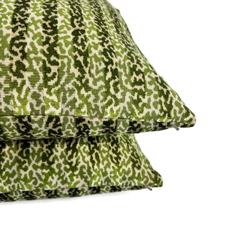 May include: Two green and white patterned throw pillows with a zipper closure.