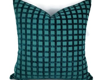 May include: Teal blue square patterned throw pillow with a soft velvet texture.