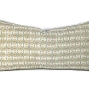 May include: Rectangular decorative pillow with a repeating pattern of interlocking circles in beige and light gray. The pillow has a soft, textured appearance and is designed for home decor.