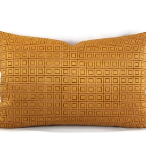 May include: A mustard yellow throw pillow with a geometric pattern of squares.
