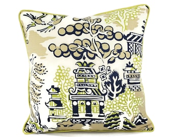 May include: A decorative throw pillow with a white background and a blue and green willow pattern. The pillow has a lime green border.