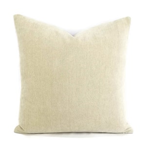 May include: A beige linen throw pillow with a square shape and a subtle texture.