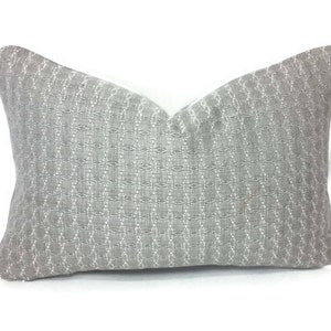 May include: A rectangular decorative pillow with a gray woven pattern. The pillow has a textured surface and a white border. The pillow is designed for home decor and adds a touch of elegance to any room.