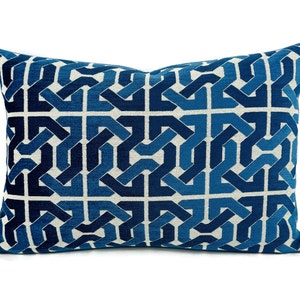 May include: Blue and white geometric patterned throw pillow with a woven design.