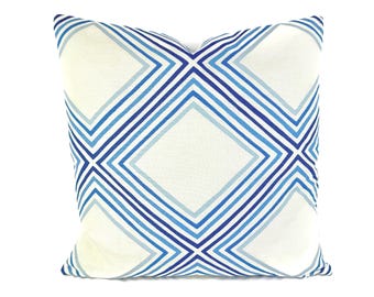 May include: A white throw pillow with a blue and light blue geometric pattern of diagonal lines forming diamond shapes.