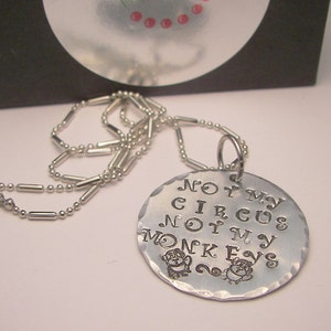 May include: Silver necklace with a round pendant that says "Not my circus, not my monkeys" with two small monkey illustrations.