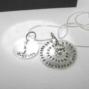 May include: Silver necklace with two round pendants. One pendant has the initials "S & J" and the date "4.17.09". The other pendant has the text "God bless you and guide you on the broken road" and a small heart charm.