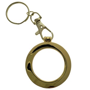 May include: Gold-toned coin keychain with a round, open frame and a silver-toned swivel clasp.