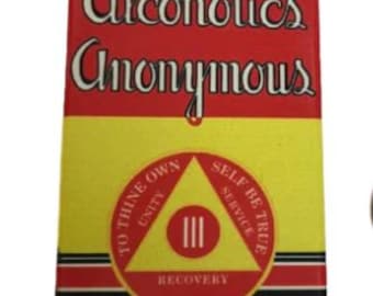 Peut inclure: Un panneau rectangulaire rouge et jaune avec le texte "Alcoholics Anonymous" en lettres blanches. Le panneau présente un triangle jaune avec le texte "To thine own self be true" et "Unity, Service, Recovery" en lettres noires.