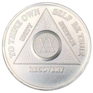 May include: Silver coin with a triangle design and the words "To Thine Own Self Be True" and "Unity, Service, Recovery" around the triangle. The number "XX" is in the center of the triangle.