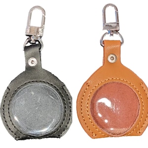 May include: Two leather keychains with a clear plastic window. One keychain is black and the other is brown.
