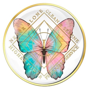 Peut inclure: Un objet rond en verre transparent avec un bord doré et un motif de papillon. Le papillon a des ailes turquoise, roses et jaunes. Le texte doré indique "NEVER ALONE", "CLEAN & SERENE", "HIGHER POWER" et "FREEDOM & SERVICE".