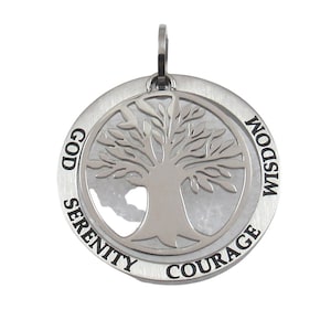 Op de afbeelding: Zilveren hanger met een levensboomontwerp en de woorden "God, Serenity, Courage, Wisdom" rond de rand.