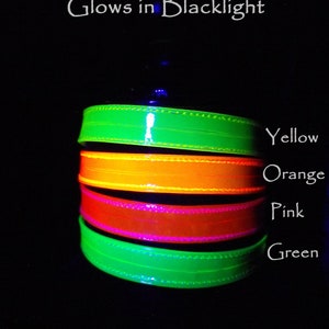 May include: A stack of four UV reactive bands in yellow, orange, pink, and green, glowing brightly against a black background. The text "UV Reactive Glows in Blacklight" and "Darkest Candy Designs" are also visible.