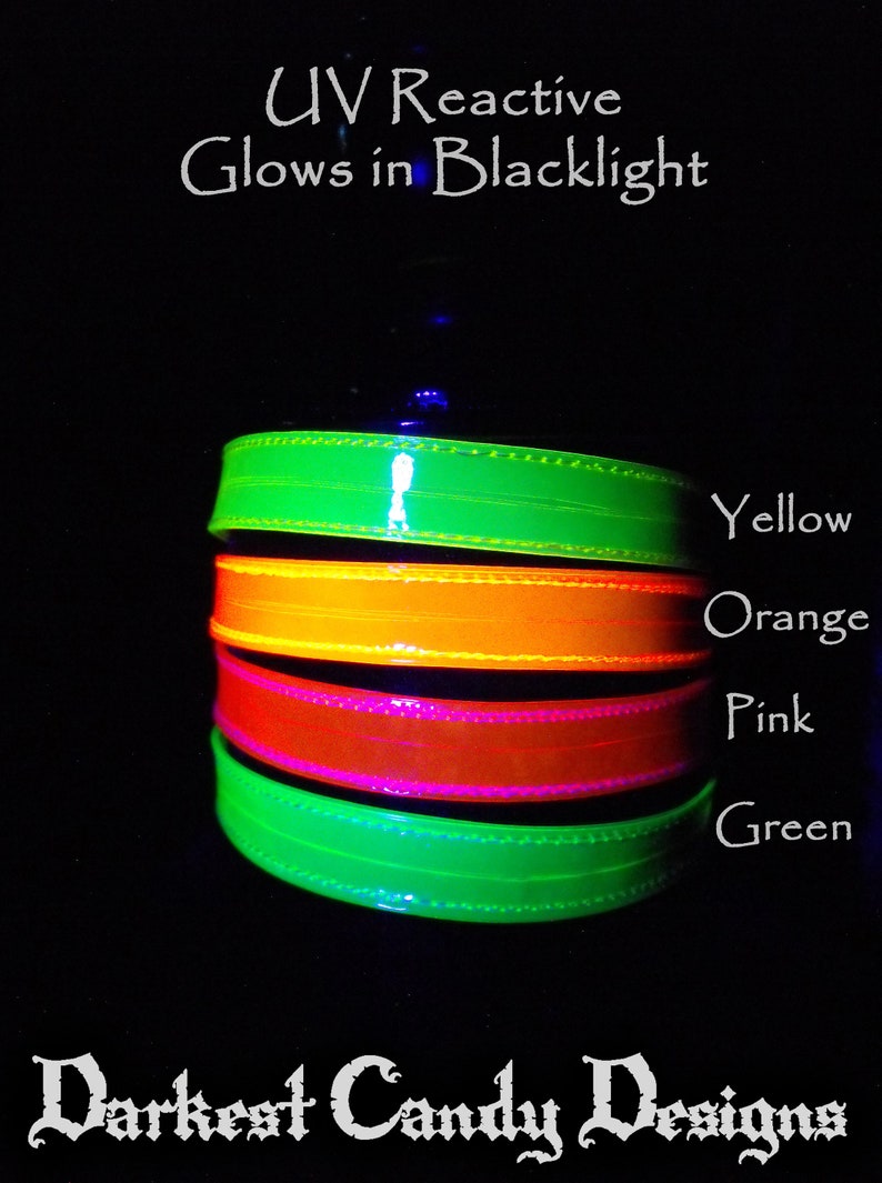 May include: A stack of four UV reactive bands in yellow, orange, pink, and green, glowing brightly against a black background. The text "UV Reactive Glows in Blacklight" and "Darkest Candy Designs" are also visible.