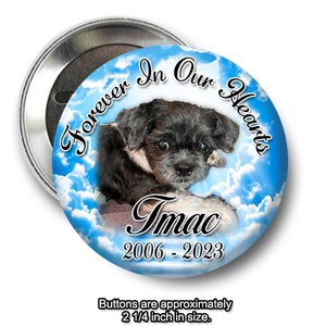 May include: A round button with a blue sky and white clouds background. A black and white dog is in the center of the button. The text "Forever In Our Hearts" is above the dog and the text "Imac 2006-2023" is below the dog. The button is 2 1/4 inches in size.