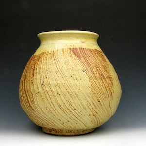 May include: A yellow ceramic vase with brown streaks and a textured surface.