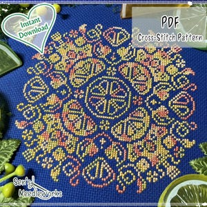 Könnte beinhalten: Ein PDF-Kreuzstichmuster mit einem kreisförmigen Mandala-Design, das mit gelbem, orangem und rosafarbenem Garn auf einem dunkelblauen Stoff gestickt ist. Das Design enthält geometrische Formen und Zitrusmotive mit dem Text PDF Cross-Stitch Pattern.